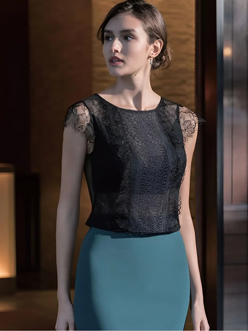 A model wearing a black lace cap-sleeve top with a high neckline, paired with teal-colored high-waisted silk skirt.