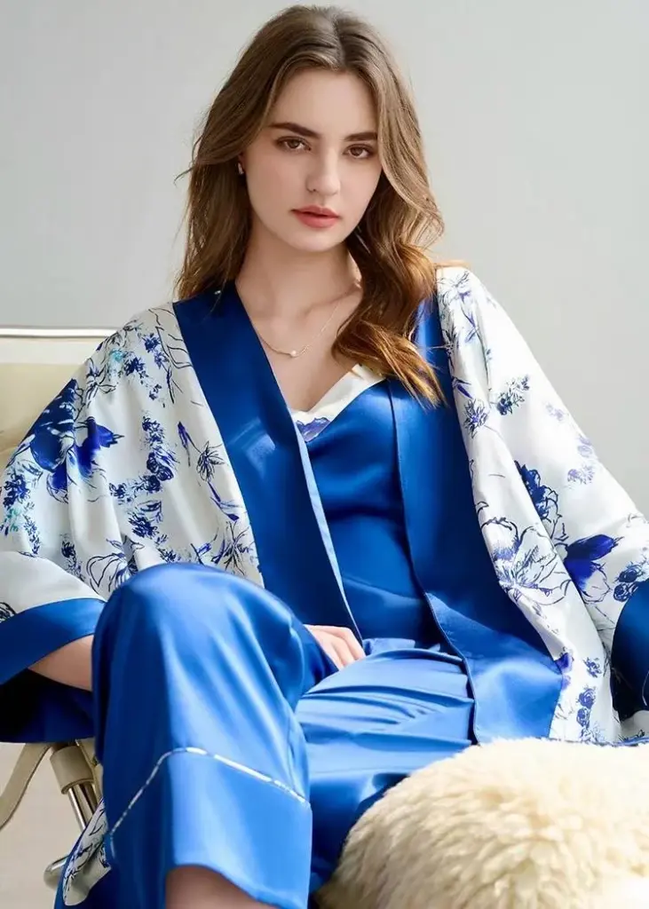 A model showcasing a deep blue silk lounge robe over a white floral printed slip dress, reflecting mixed-pattern expertise.
