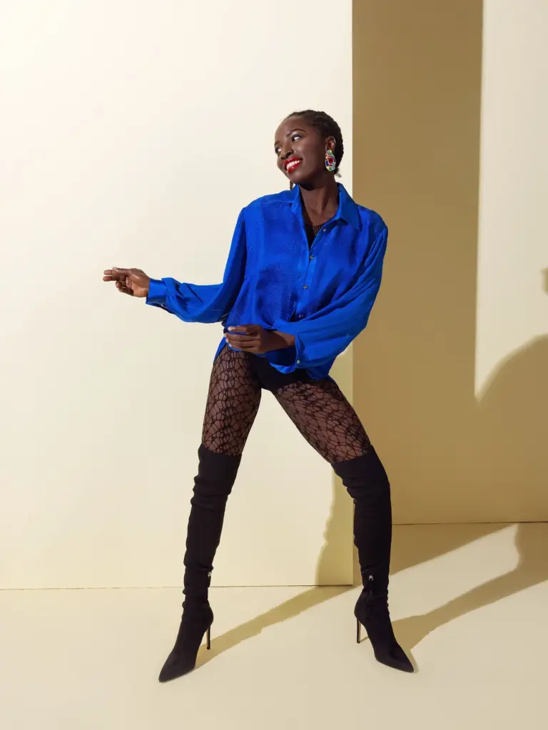 An oversized deep blue shirt in Viscose Jacquard fabric with an elegant woven texture, paired with patterned lace tights for a contemporary look.