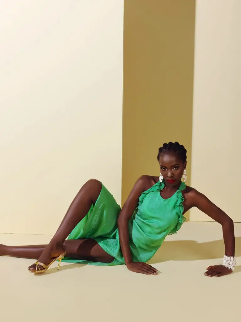 A model wearing a contemporary maxi dress with a bold green and grey abstract print, manufactured from premium natural silk.