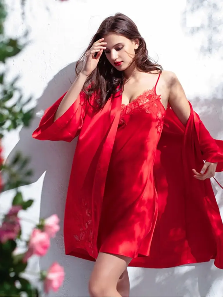 A model showcasing a vibrant red silk robe and matching red lace slip dress, reflecting colorful urban style.
