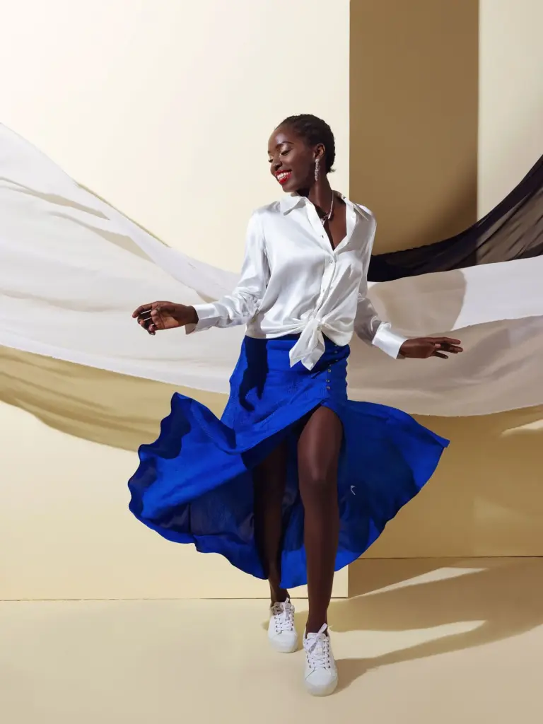 A model wearing a high-slit maxi skirt made of deep blue Viscose Jacquard, highlighting the fabric's premium drape and sophisticated woven pattern.